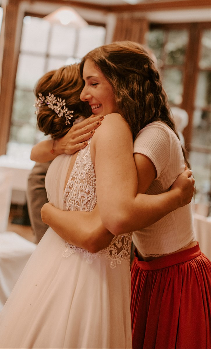 Umarmung mit Hochzeitsgästen